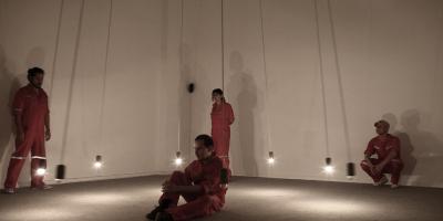 Cuatro personas en una sala donde hay péndulos lumínicos